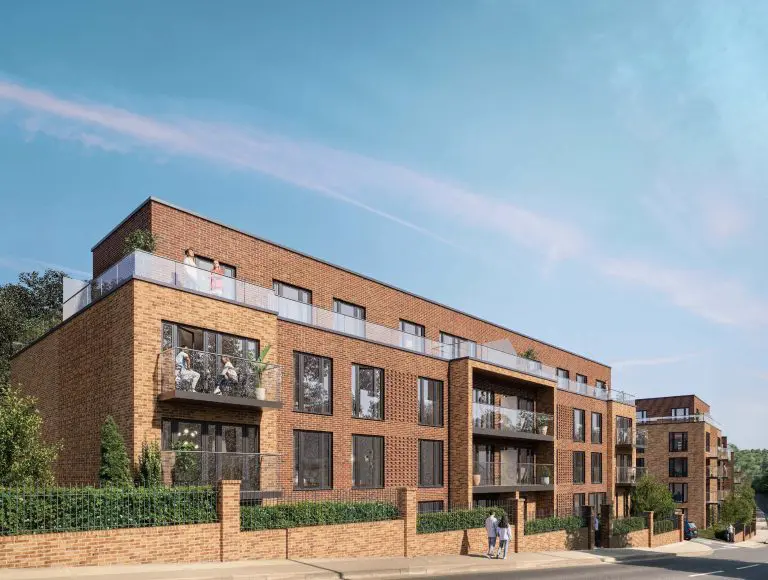 Exterior render of Interchange Residences showing red-brick apartment building with residents relaxing on a rooftop terrace and private balconies overlooking a tree-lined street.
